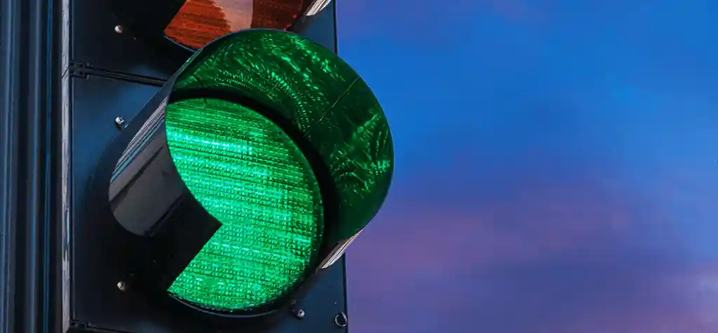 Semáforo aberto no verde contra o céu do fim de tarde
