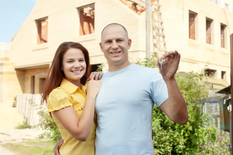 Um casal está feliz com a regularização fundiária do seu imóvel.