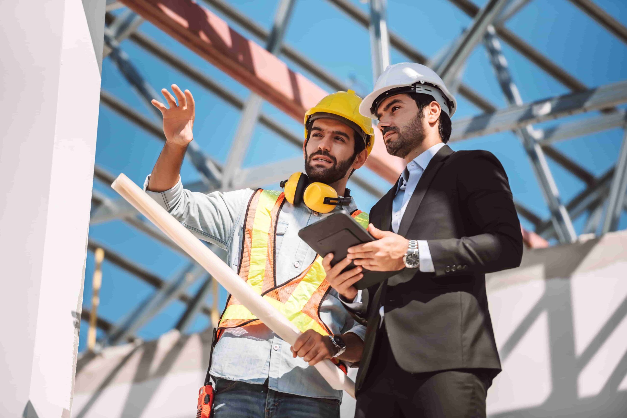 Um gestor de obras conversa com um engenheiro sobre o projeto de comissionamento.